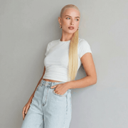 Model showcasing beach blonde ponytail hair extension styled with a white top and light jeans.