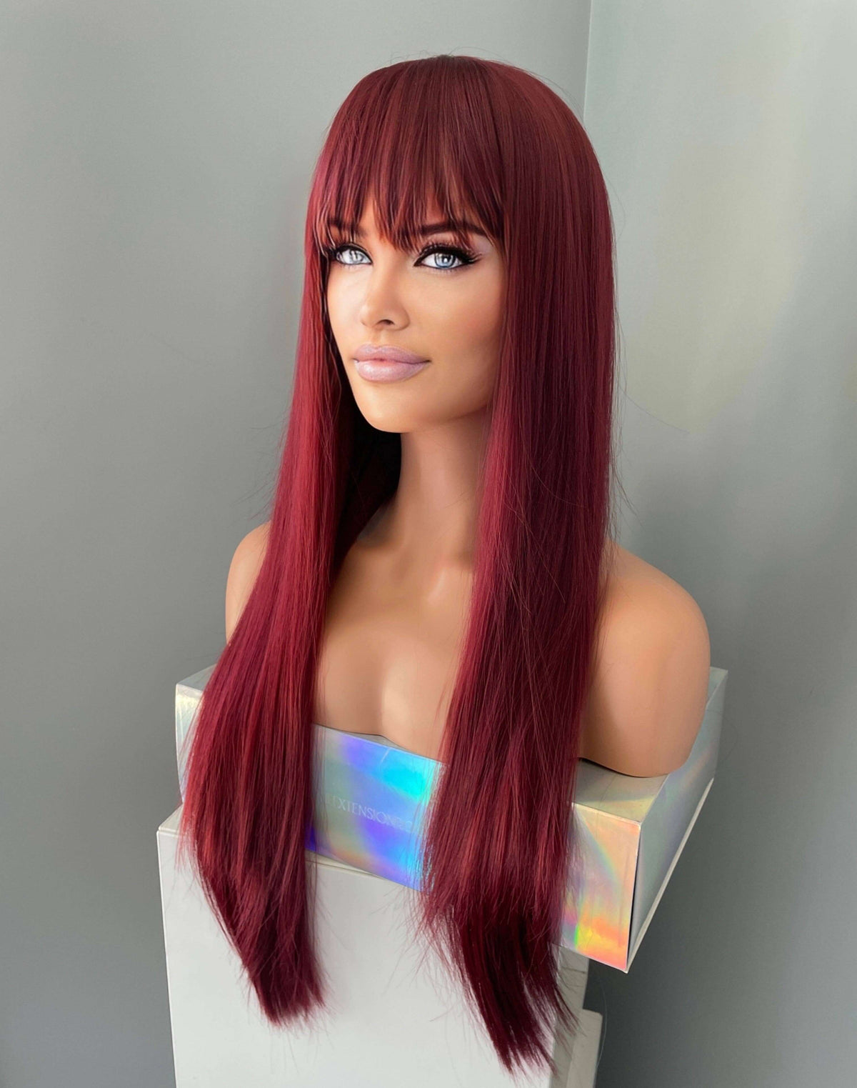 long wine red silky straight wig with bangs displayed on a mannequin, showcasing its sleek and vibrant appearance.